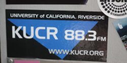 Photo of wall at college radio station KUCR, with KUCR 88.3 sticker in the center. Photo: J. Waits
