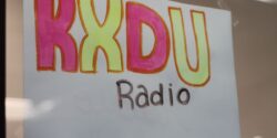 Photo of hand-drawn sign that reads KXDU Radio. Photo: Jennifer Waits