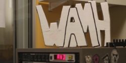 Photo of WAMH sign perched atop audio equipment in the Amherst College radio station WAMH. Photo: J. Waits